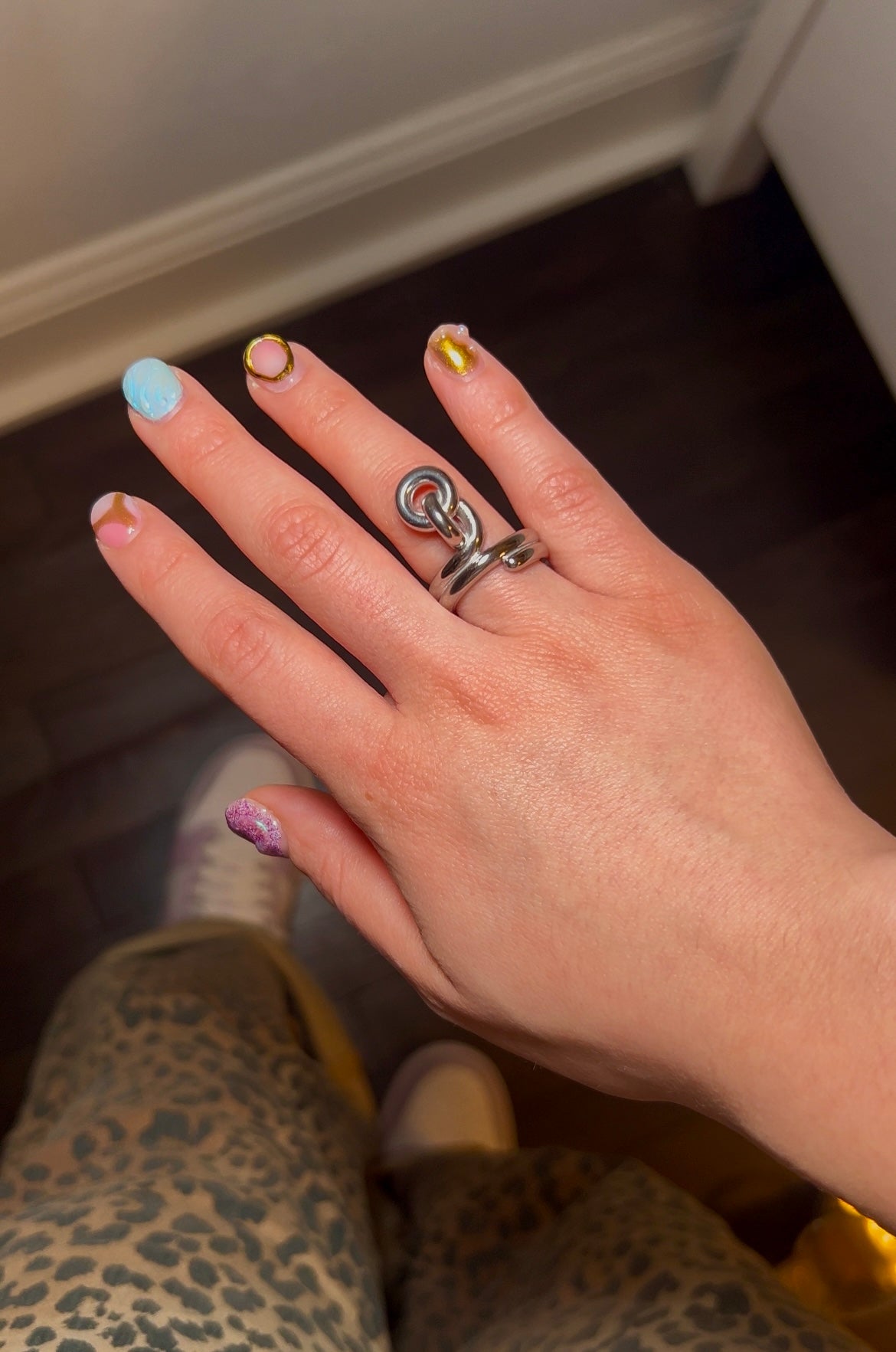 Close-up of dainty gold knot ring – non-adjustable, classic fit