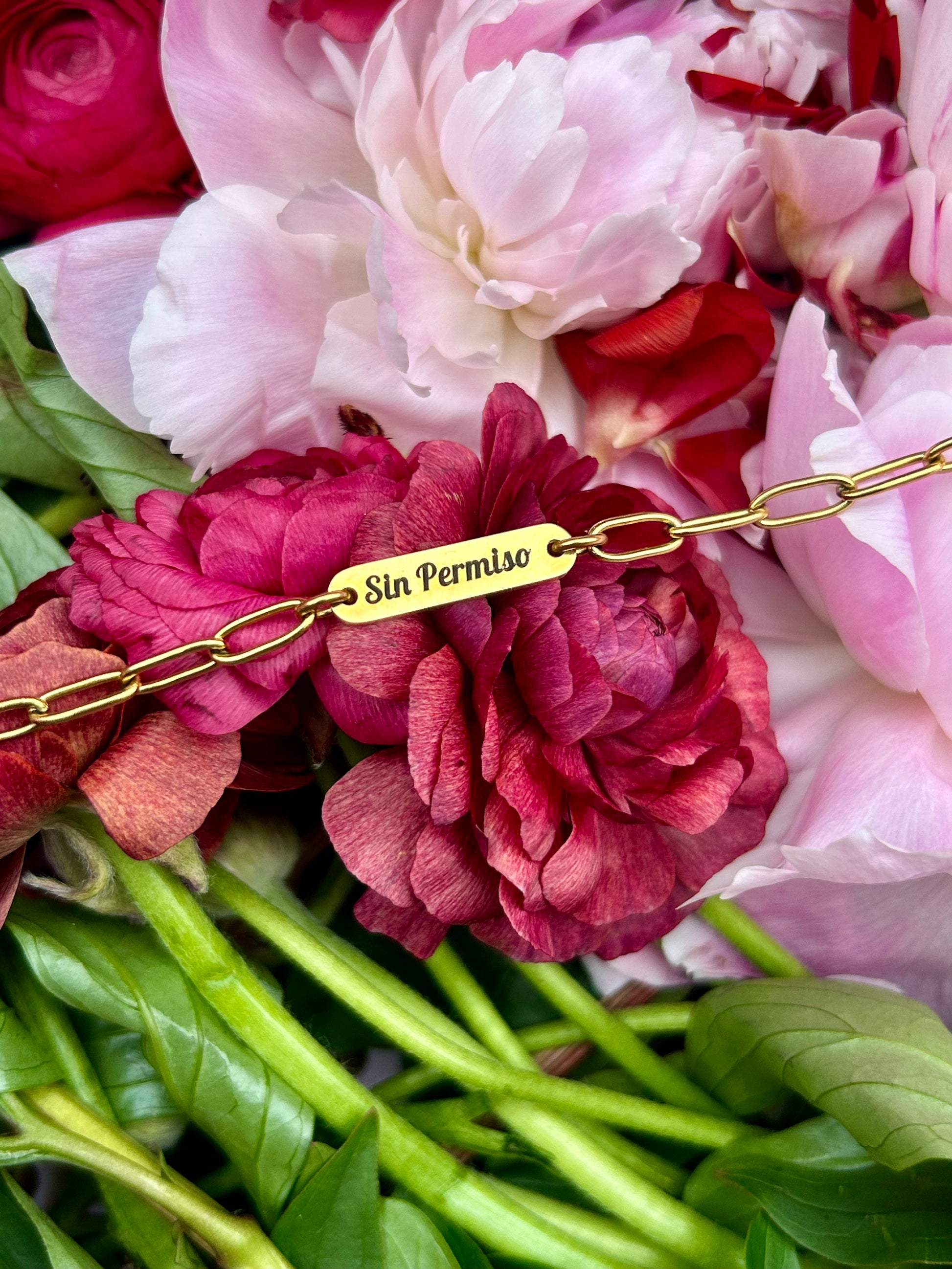Gold Engraved Bracelet laying over a bed of flowers