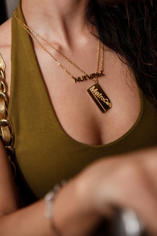 Gold MetroCard necklace on model wearing white tank top NYC jewelry