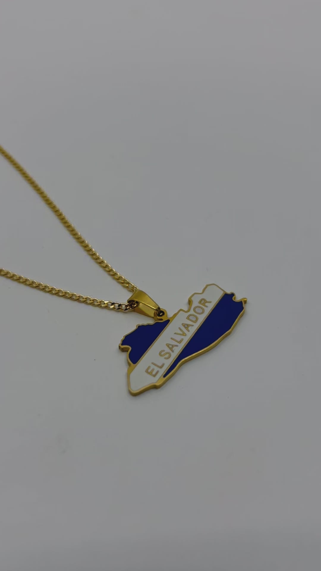 El Salvador map necklace styled with layered gold chains