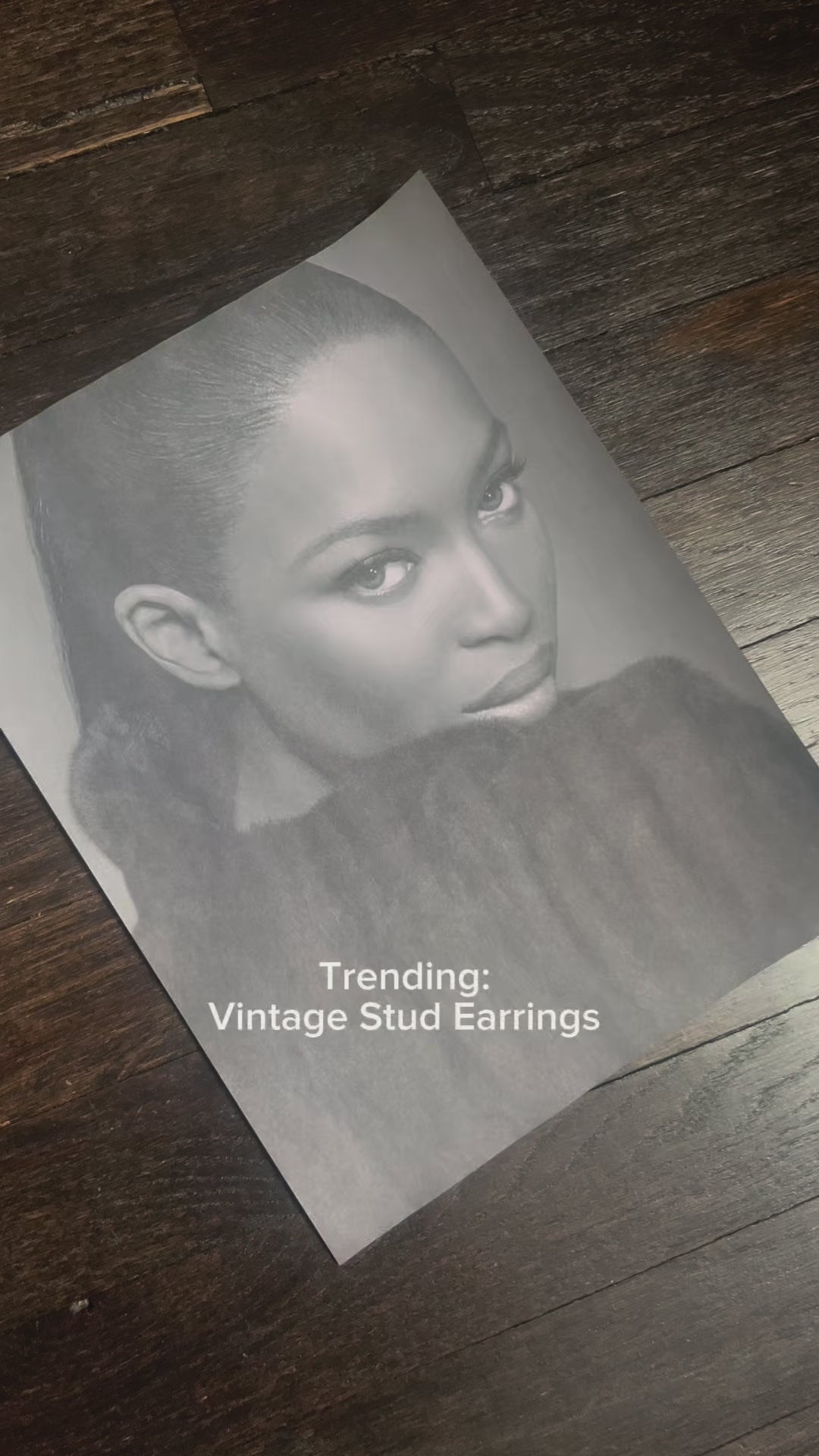 Model wearing vintage-inspired gold stud earrings with slick bun hairstyle