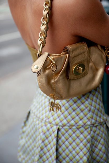 Tropical nostalgic scene bag charm in gold-tone stainless steel on model