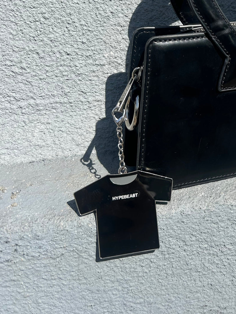 Black Hypebeast keychain on bag with textured gray surface
