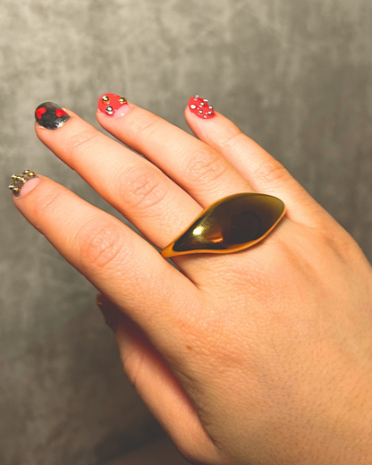 Hand with a gold ring on a neutral background