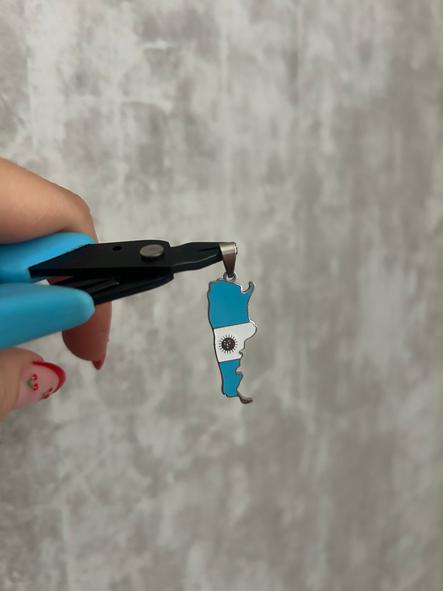 Argentina Flag necklace being held by pliers