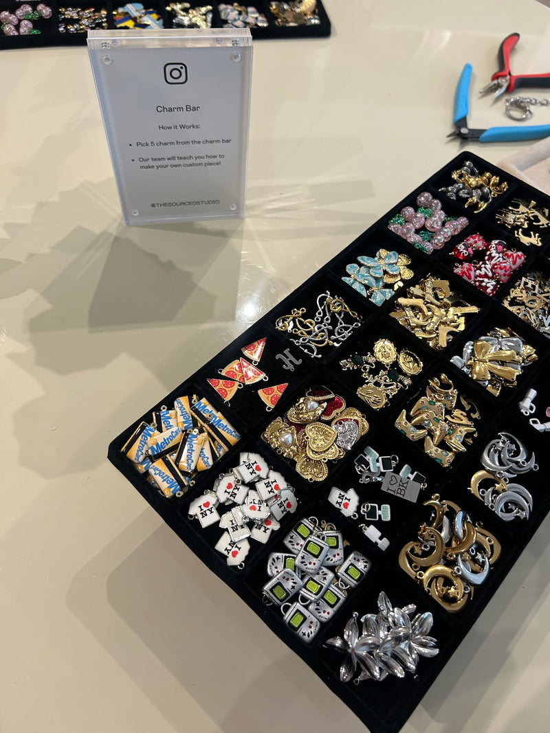 Collection of charms on a display card with tools in the background