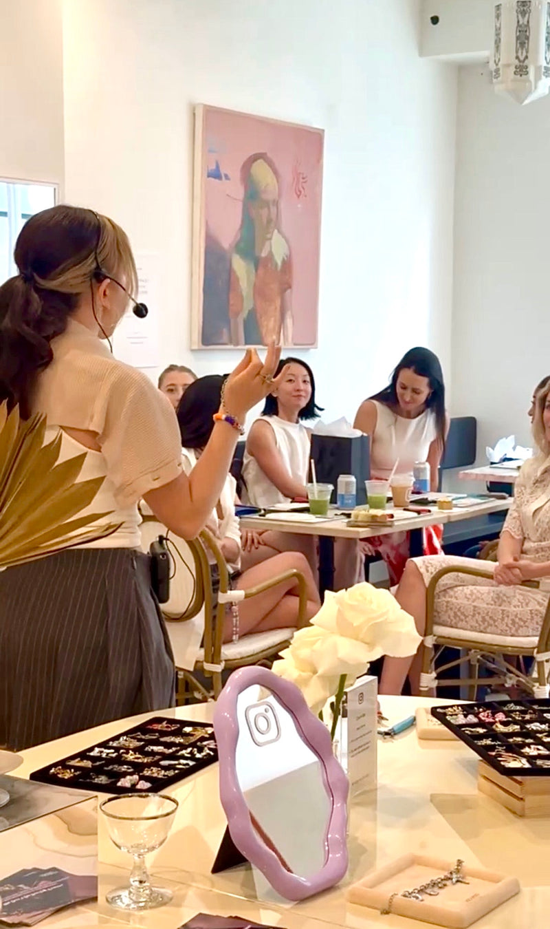 Woman giving a presentation in a classroom setting with other participants.
