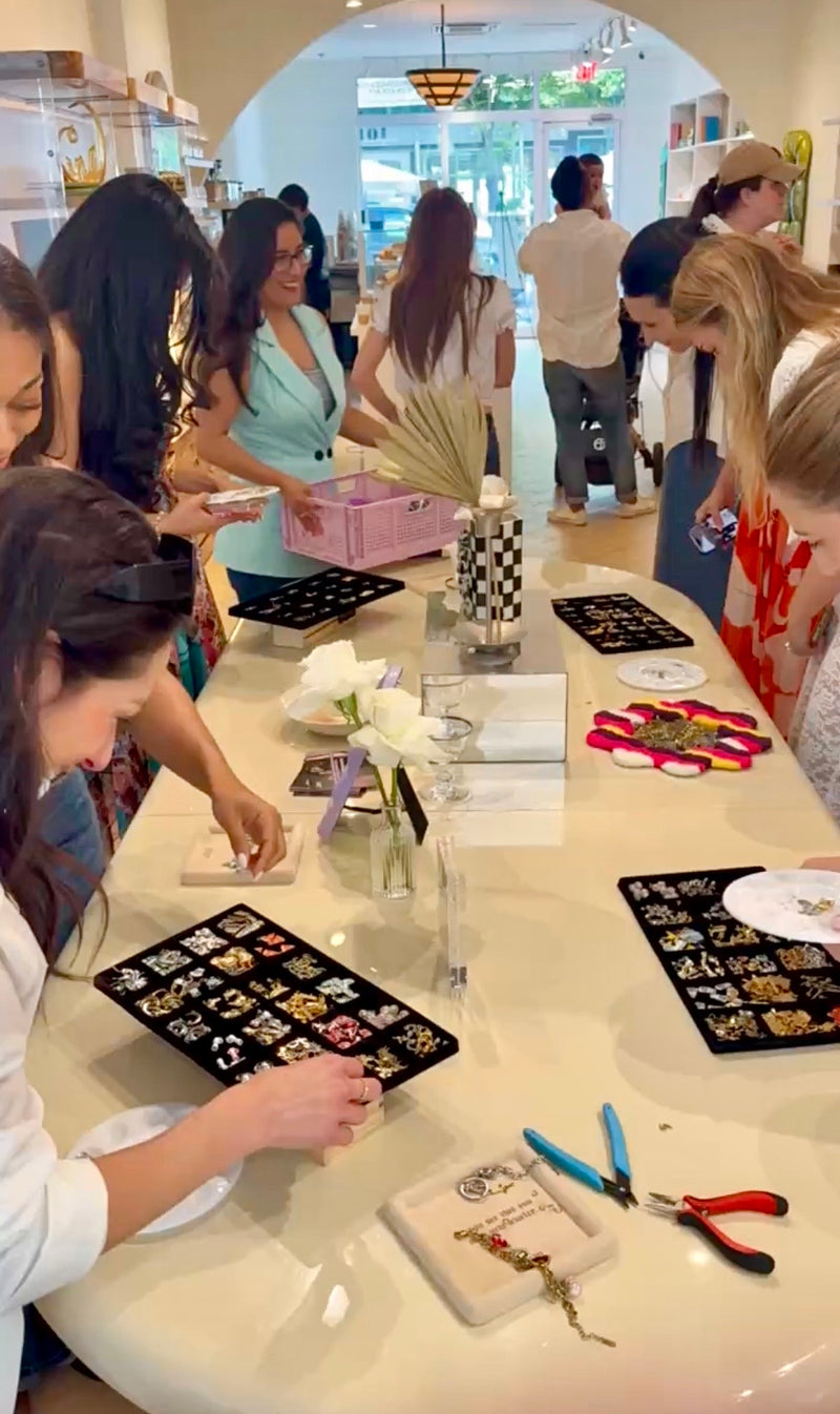 Group of people at a table with craft materials in a casual setting