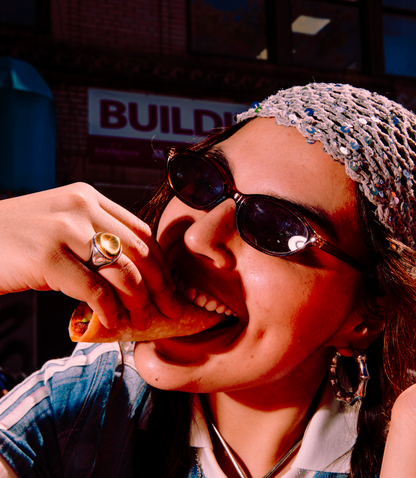 Person wearing sunglasses and a beaded headband with a blurred background