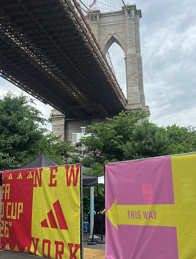 Brooklyn Bridge with colorful directional signs in the foreground