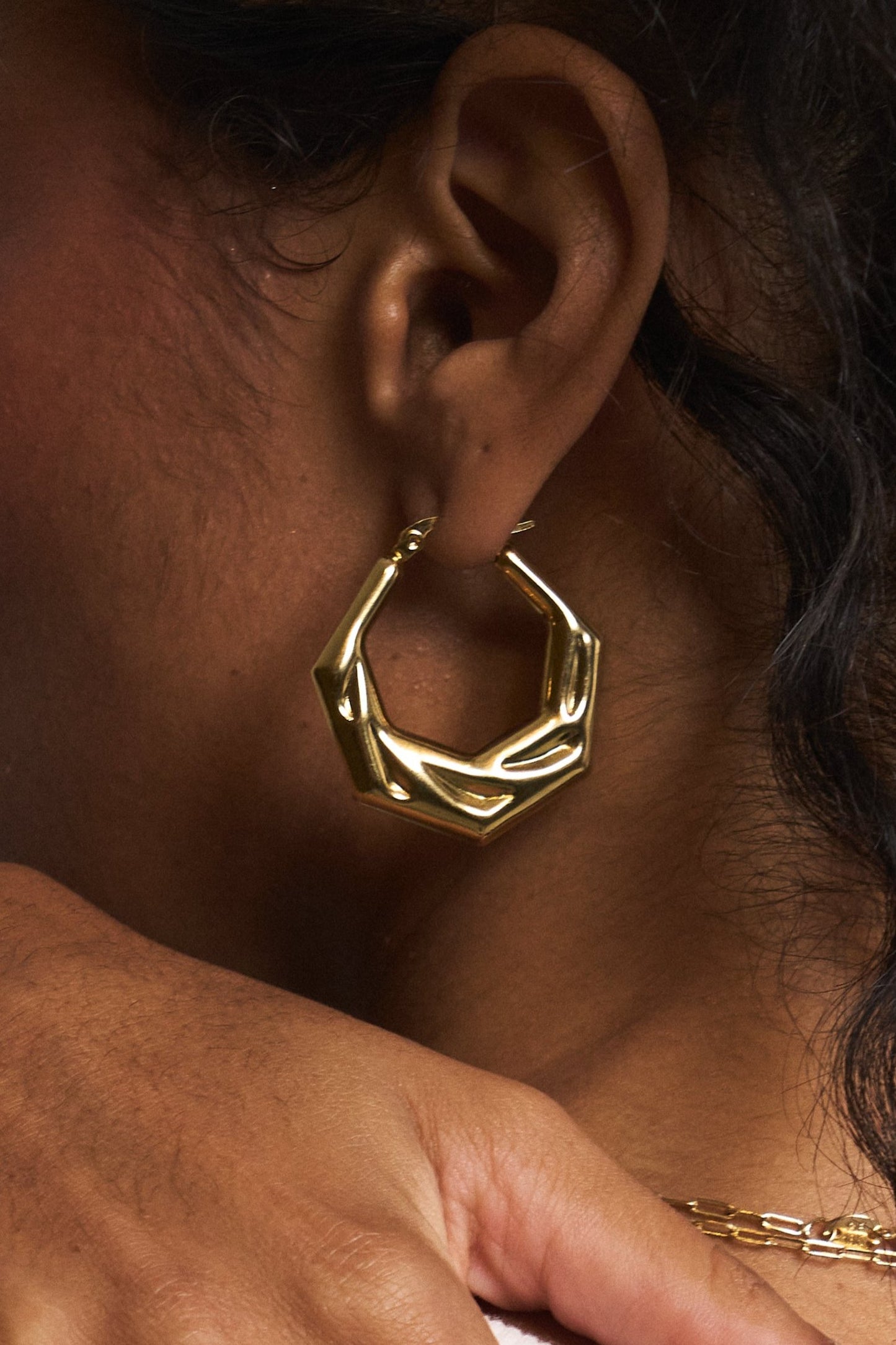 Detailed view of gold geometric hoop earrings in stainless steel