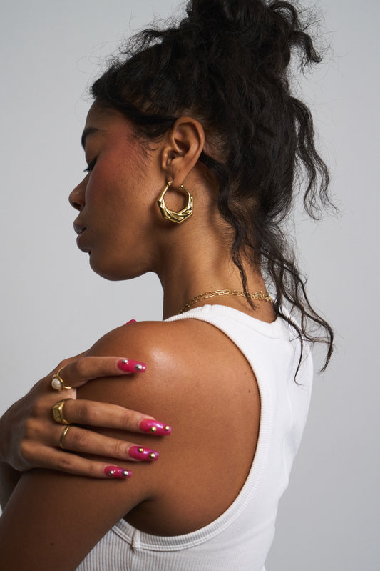 Model wearing gold geometric huggie hoops – angular minimalist earrings