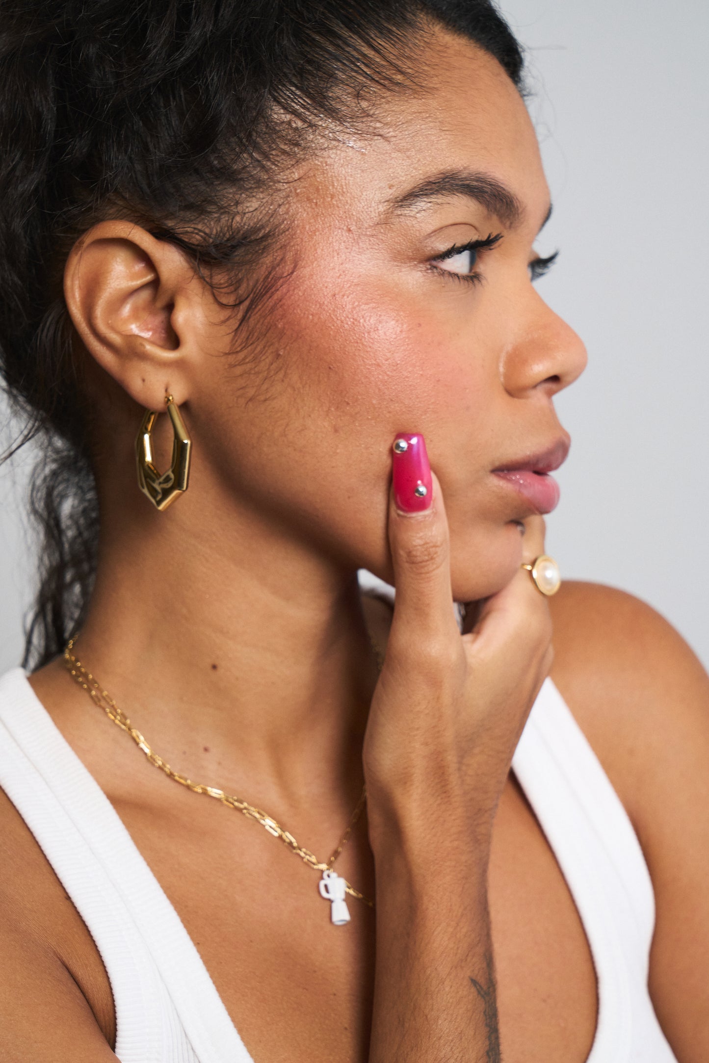 Close-up of gold angular hoop earrings with geometric silhouette